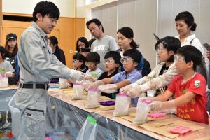 セメントと砂の入った袋に、学生が水を入れていきます。